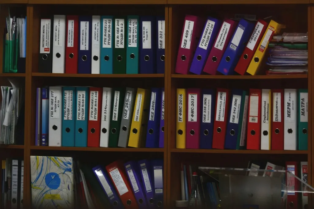 Colourful ring binders of client files on office shelves representing HMRC and Companies House portal admin records
